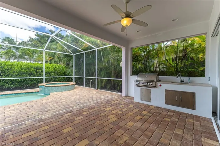 Covered outdoor patio with grilling area and sink.