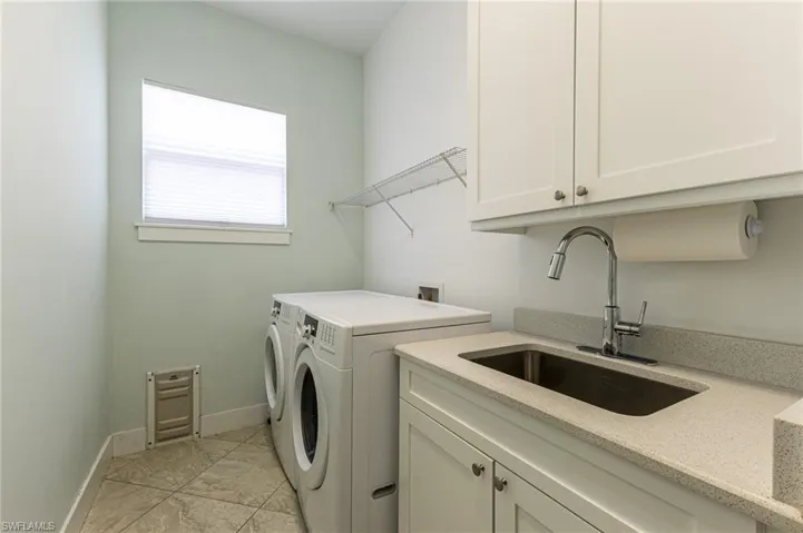 Laundry room featuring cabinet space, independent washer and dryer, and patterned tile flooring
