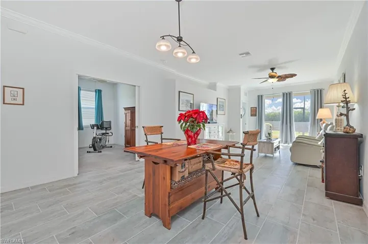 Dining area featuring crown molding and a ceiling fan