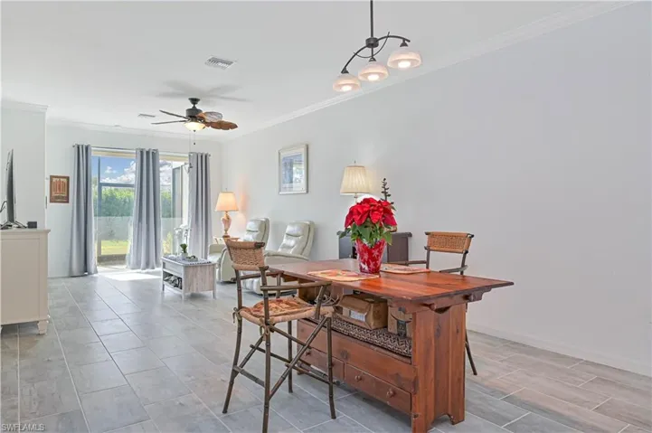 Dining space with ornamental molding and ceiling fan