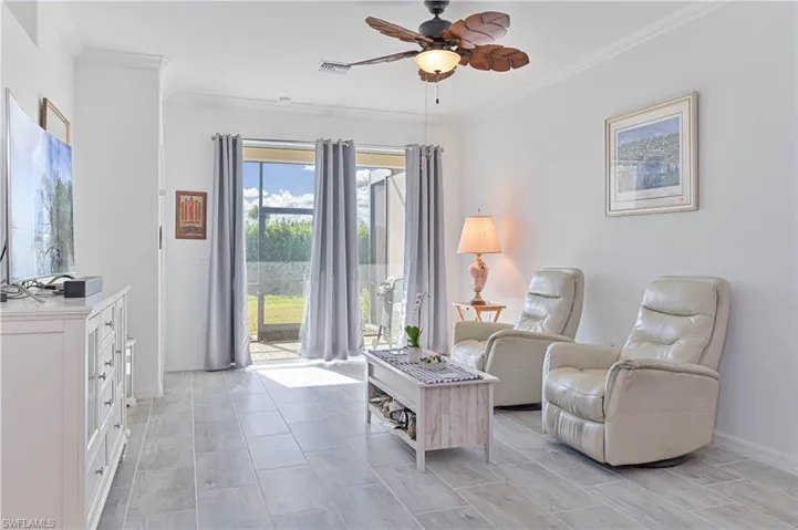 Living area with ceiling fan and crown molding