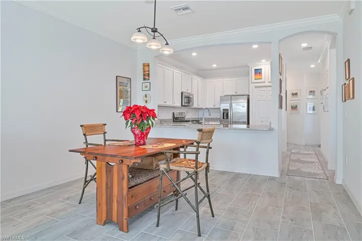 Dining room featuring crown molding, arched walkways, and recessed lighting