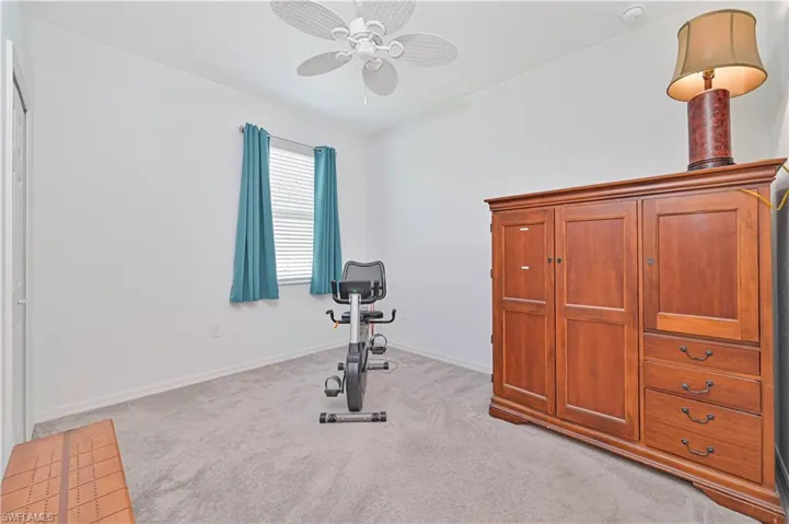 Workout area with light carpet and ceiling fan