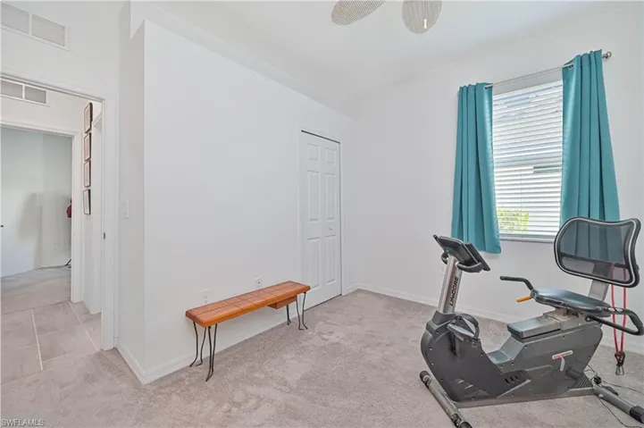 Workout room with light carpet and baseboards