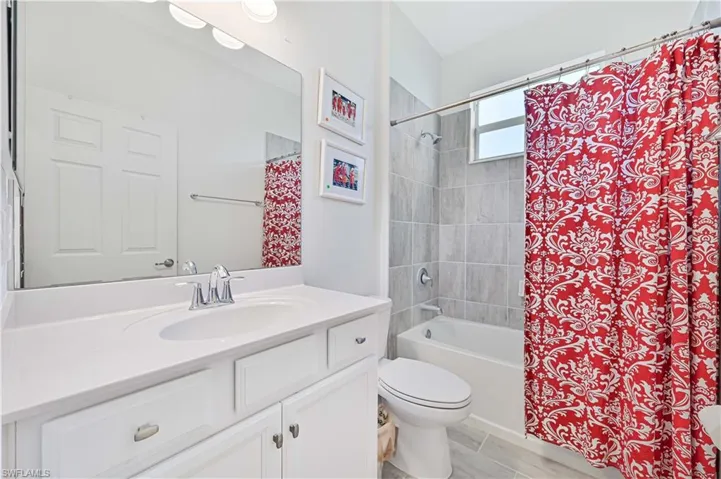 Bathroom featuring shower / bathtub combination with curtain and vanity
