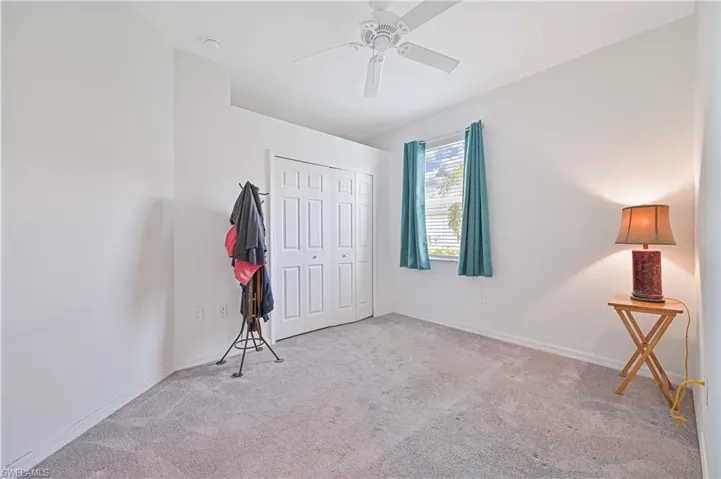Unfurnished bedroom featuring light colored carpet, a ceiling fan, and a closet