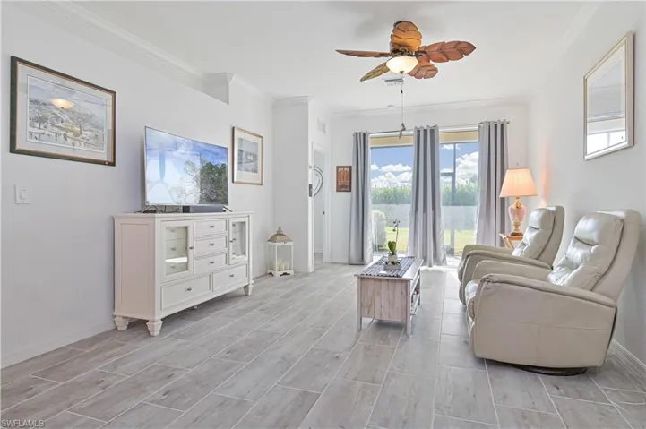 Living area with ceiling fan, ornamental molding, and wood finish floors