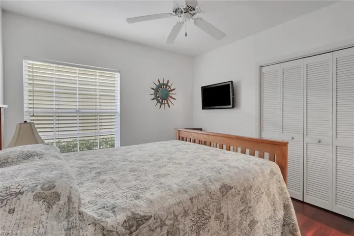 Bedroom with a closet, a ceiling fan, and dark wood finished floors