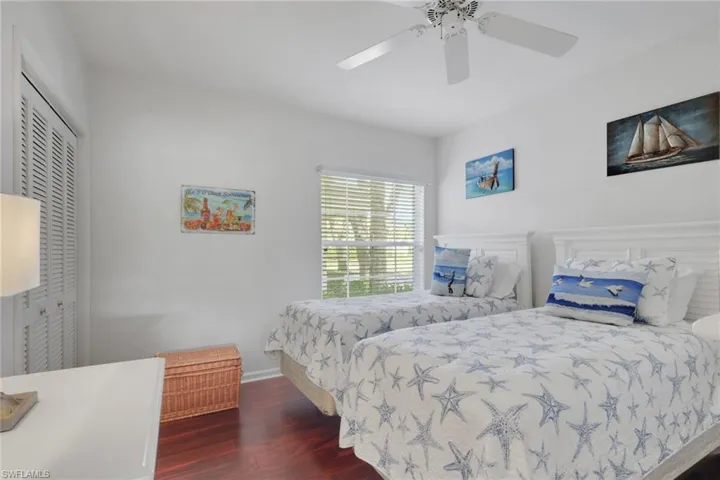 Bedroom featuring dark wood-style floors, a ceiling fan, and a closet
