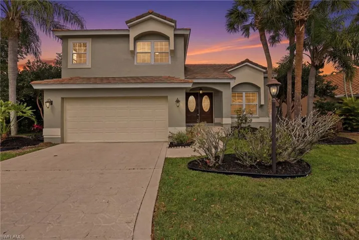 Mediterranean / spanish home featuring a garage, concrete driveway, stucco siding, and a lawn