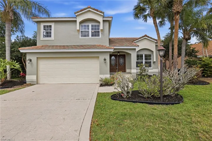 Mediterranean / spanish home with an attached garage, driveway, and stucco siding