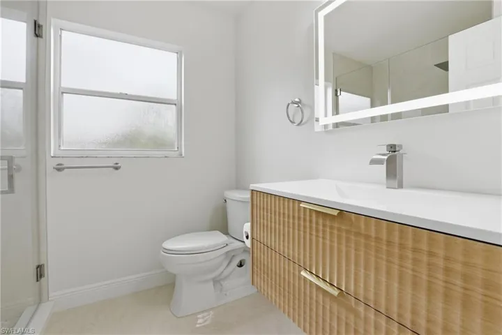 Full bath with a stall shower, vanity, and light tile patterned flooring