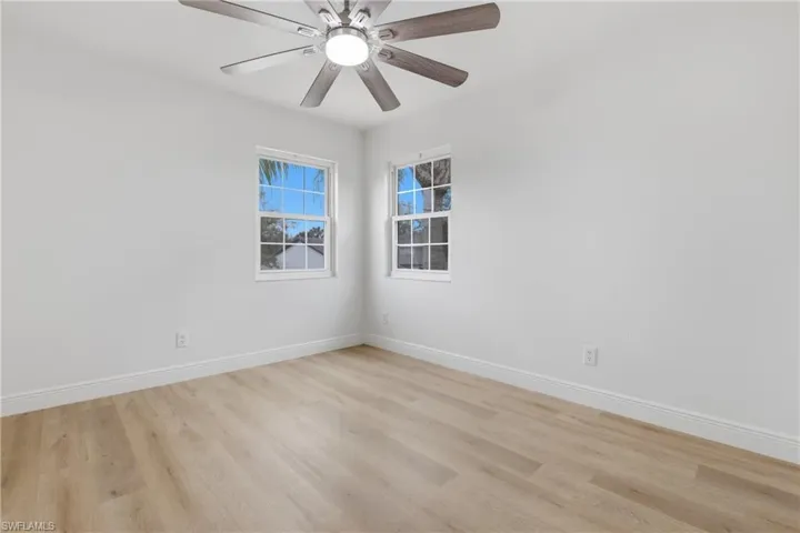 Unfurnished room with ceiling fan and light wood-style flooring