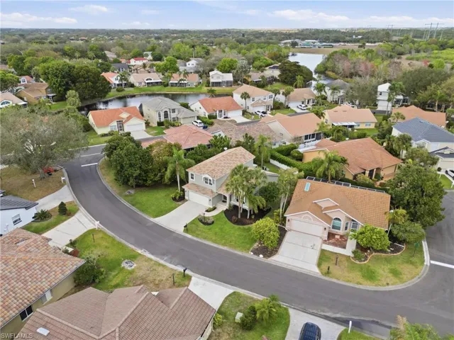 Aerial perspective of suburban area featuring a nearby body of water
