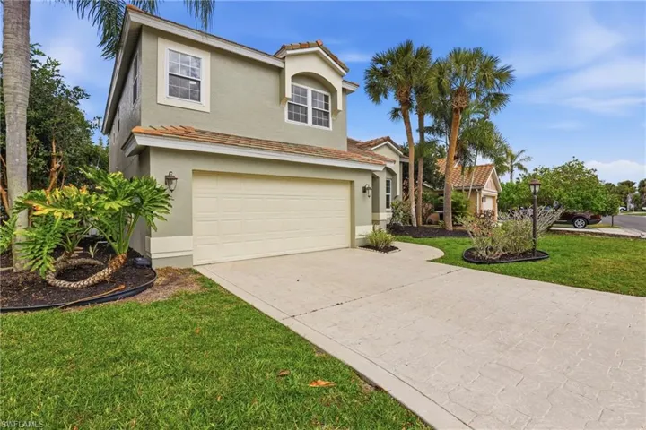 Mediterranean / spanish house featuring concrete driveway, a garage, stucco siding, a front lawn, and a tiled roof