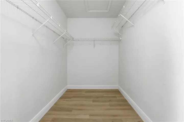 Walk in closet with light wood finished floors
