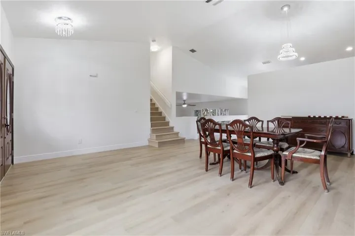 Dining space featuring light wood-style flooring, lofted ceiling, and hanging lights