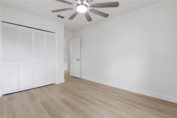 Unfurnished bedroom featuring a closet, light wood finished floors, and ceiling fan