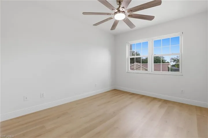 Unfurnished room featuring light wood-style flooring and ceiling fan
