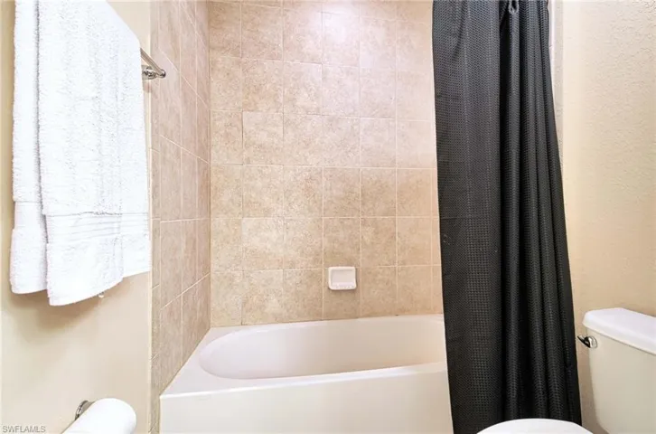 Full bath featuring toilet and shower / bath combo