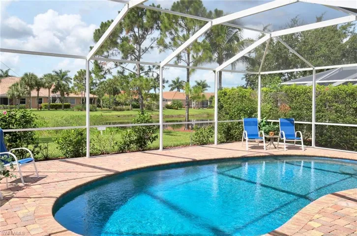 Swimming pool featuring a patio, glass enclosure, and a water view