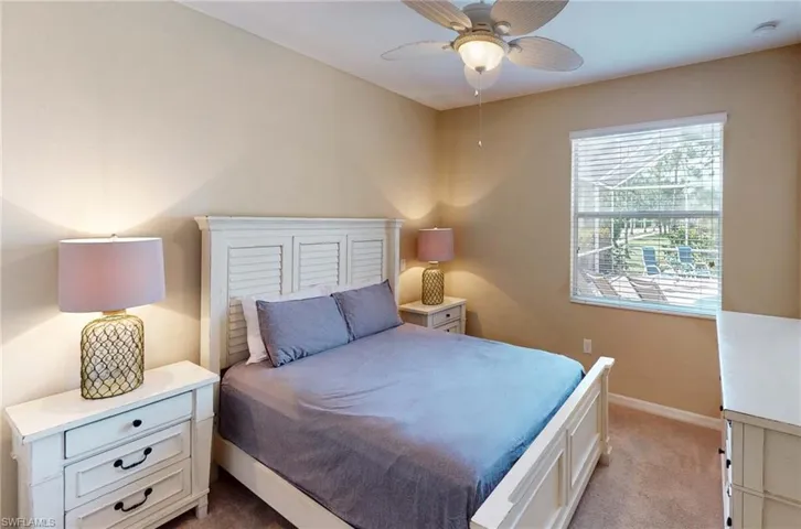 Bedroom featuring light carpet, baseboards, and ceiling fan