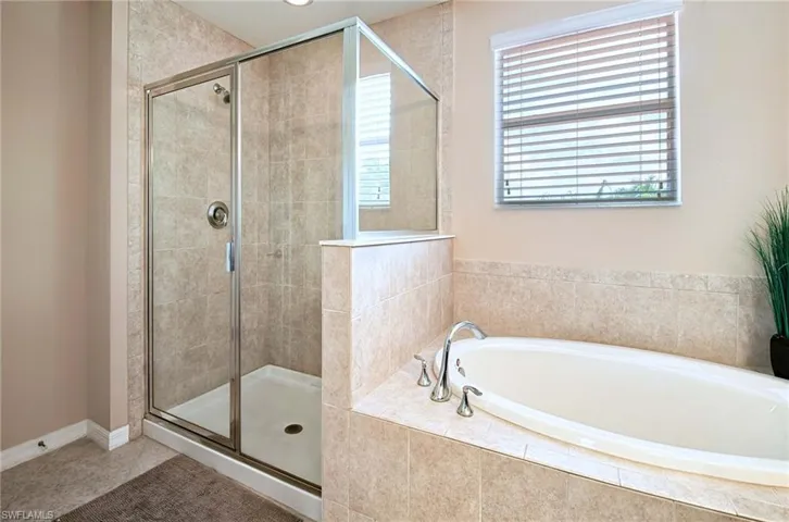 Bathroom featuring a bath and a shower stall