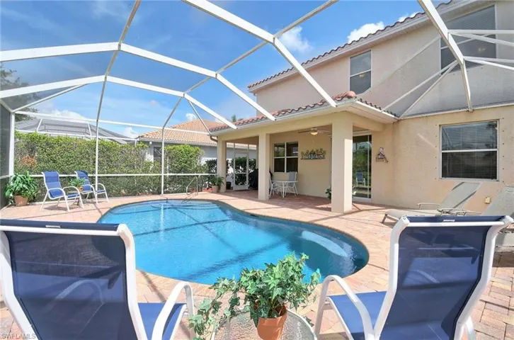 Outdoor pool featuring a patio area, a ceiling fan, and glass enclosure