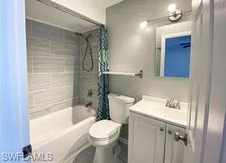 Full bath with shower / bath combo with shower curtain and vanity