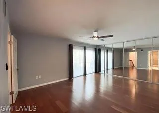 Master bedroom with a closet, dark wood-style floors, and a ceiling fan
