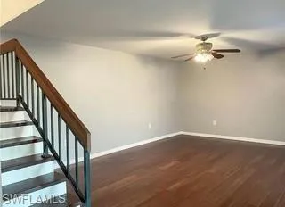 Stairway featuring wood-style floors and a ceiling fan