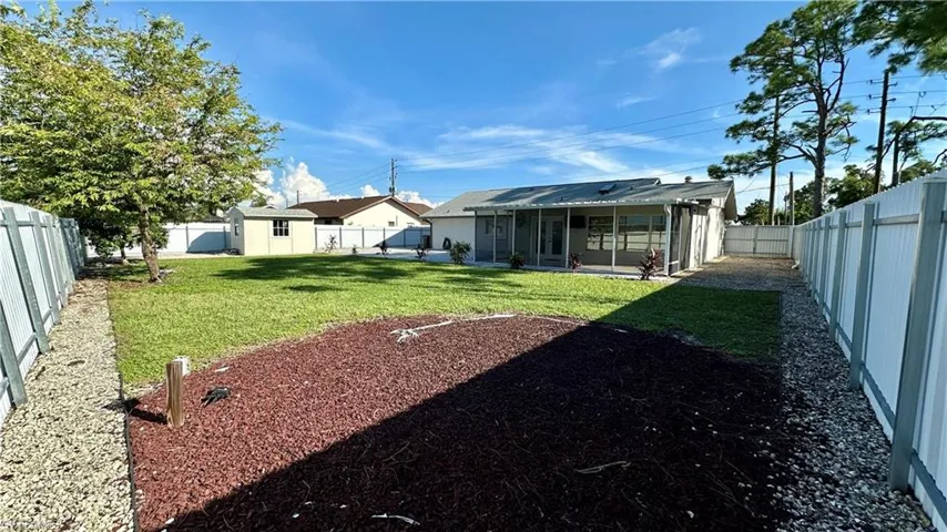 View of yard with a sunroom and a storage unit