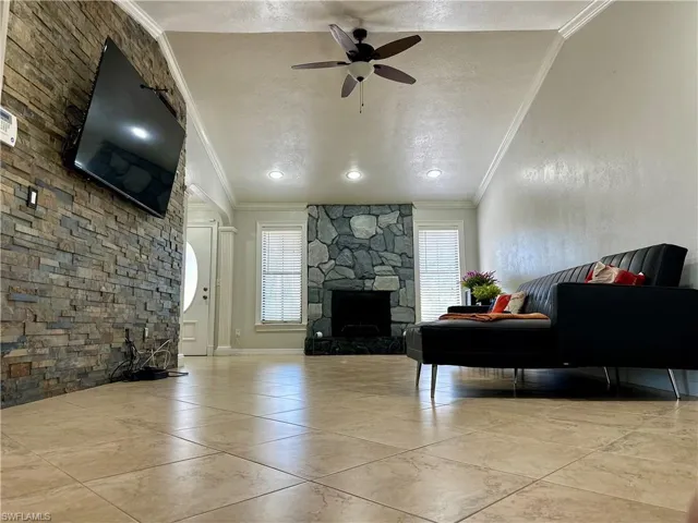 Living room with ornamental molding, a textured ceiling, and a healthy amount of sunlight