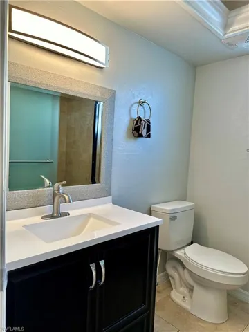 Bathroom featuring tile patterned flooring, vanity, and toilet