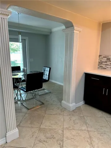 Dining space with crown molding and decorative columns