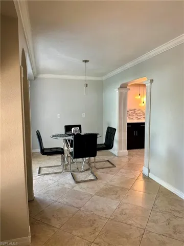 Dining area with crown molding and decorative columns