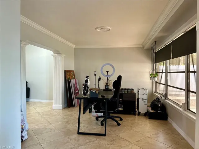 Tiled office featuring ornamental molding and ornate columns