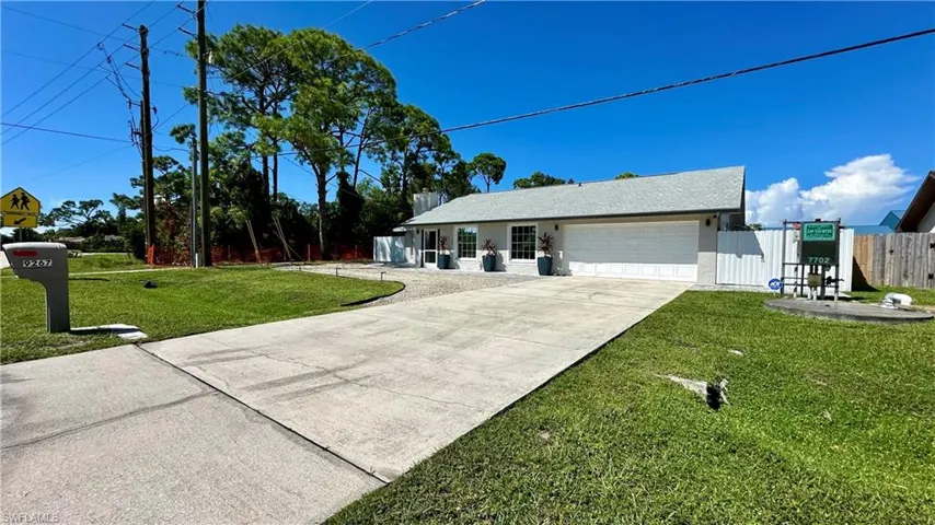Ranch-style house with a front yard and a garage