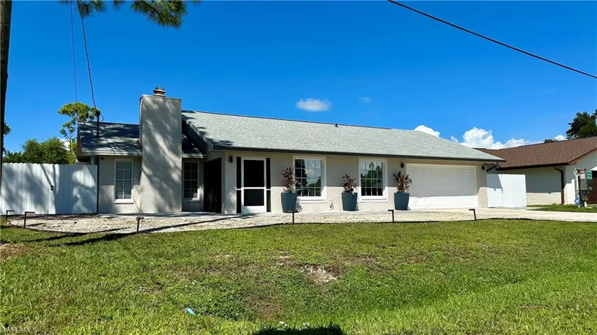 Single story home with a front lawn and a garage