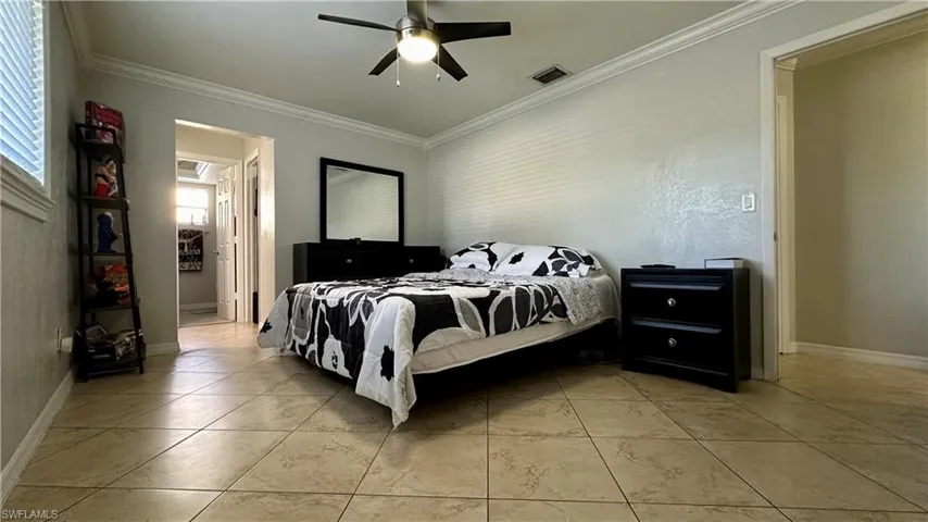 Bedroom with ornamental molding and ceiling fan