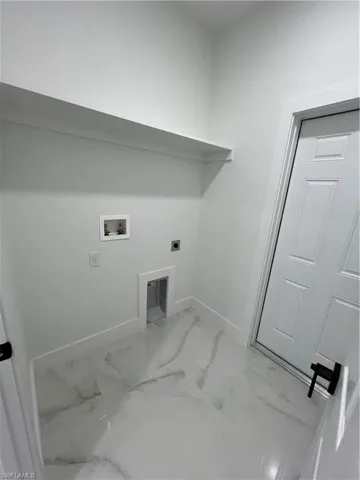 Washroom with tile floors, hookup for a washing machine, and electric dryer hookup