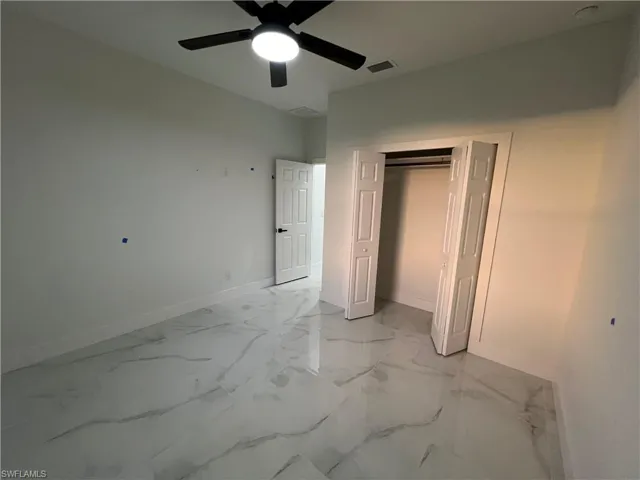 Unfurnished bedroom featuring a closet, ceiling fan, and light tile floors