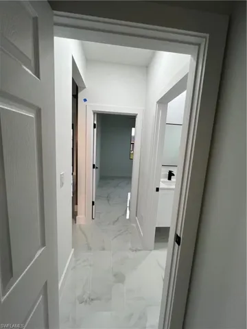Hallway featuring sink and light tile floors