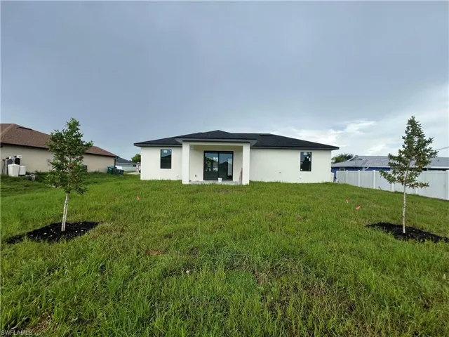 Back of property featuring a lawn