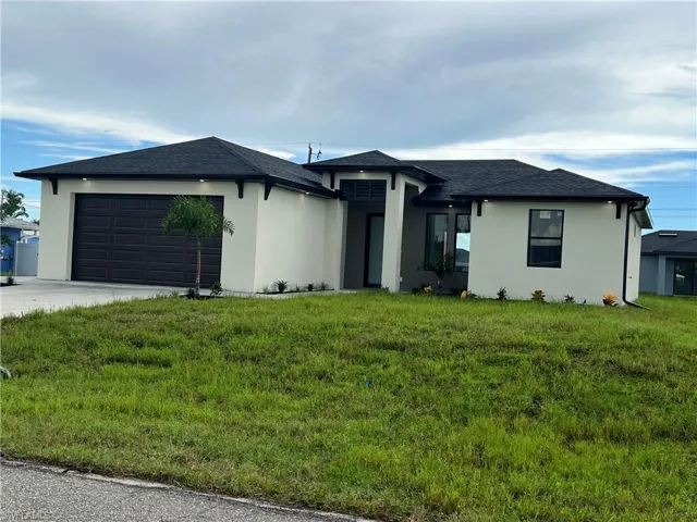 View of front of house featuring a garage and a front lawn