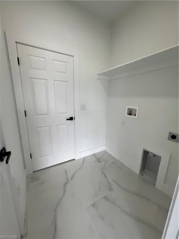 Laundry area with tile floors, hookup for a washing machine, and hookup for an electric dryer