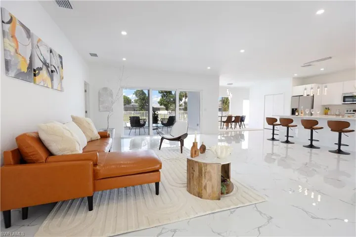 Living area featuring recessed lighting and light marble finish floors