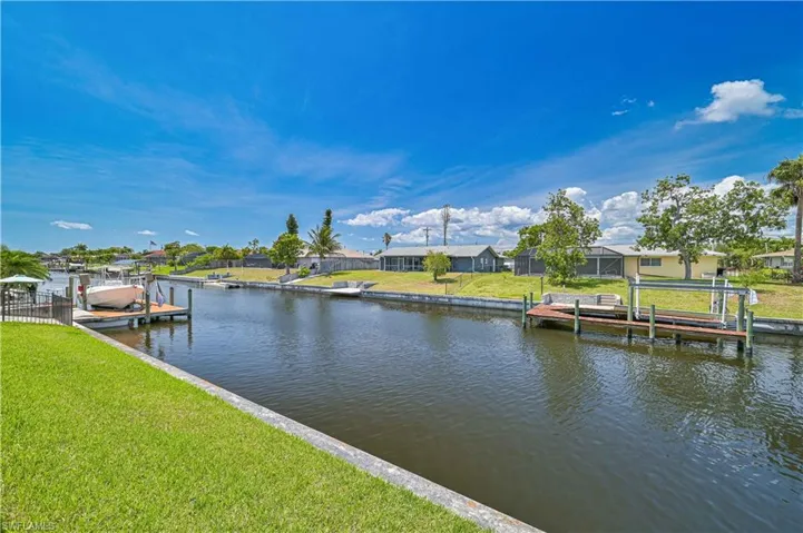 Dock area with boat lift, a residential view, and a water view