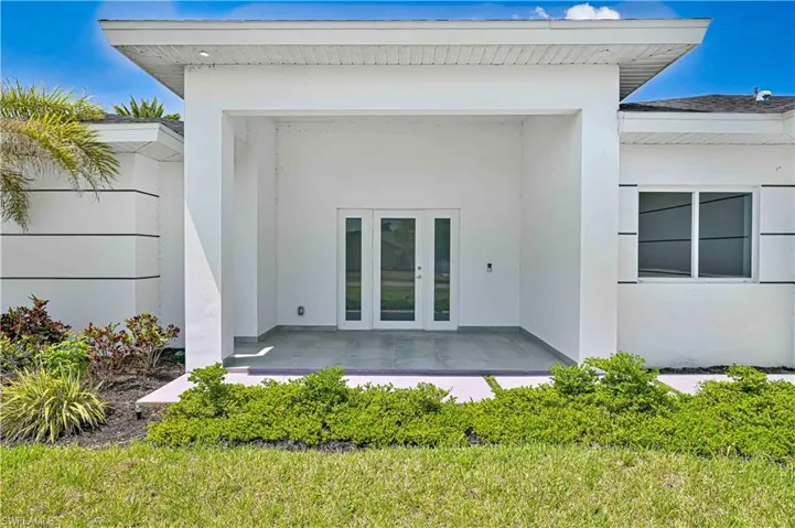 Doorway to property with french doors and stucco siding