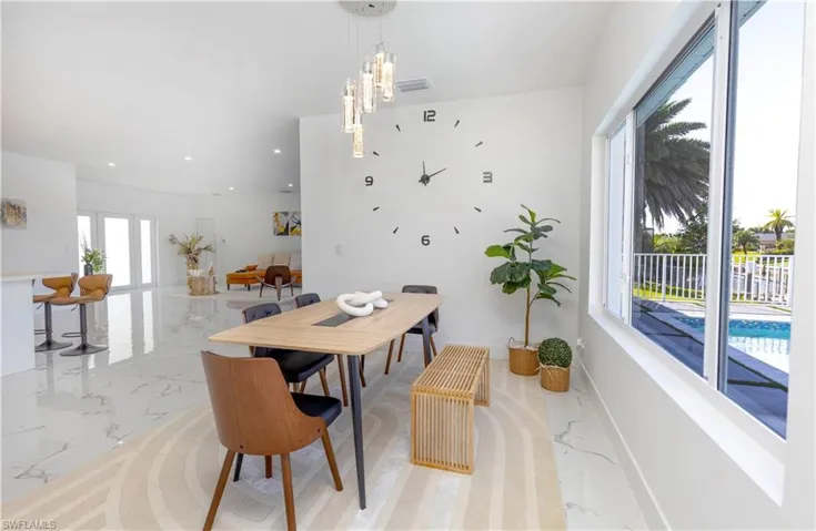 Dining area with light marble finish flooring, recessed lighting, and a chandelier